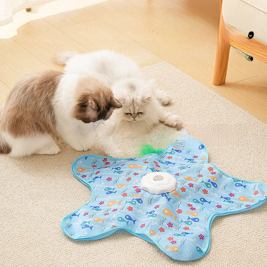 Cat playing with a blue fish-shaped mat on a carpeted floor.